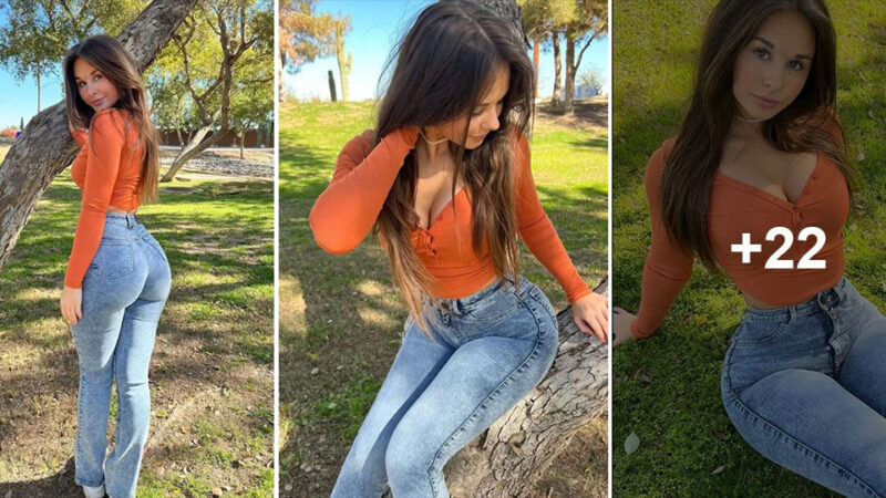 Lexi Marvel sat on the greenery, appearing soft and seductive in her orange shirt and trousers